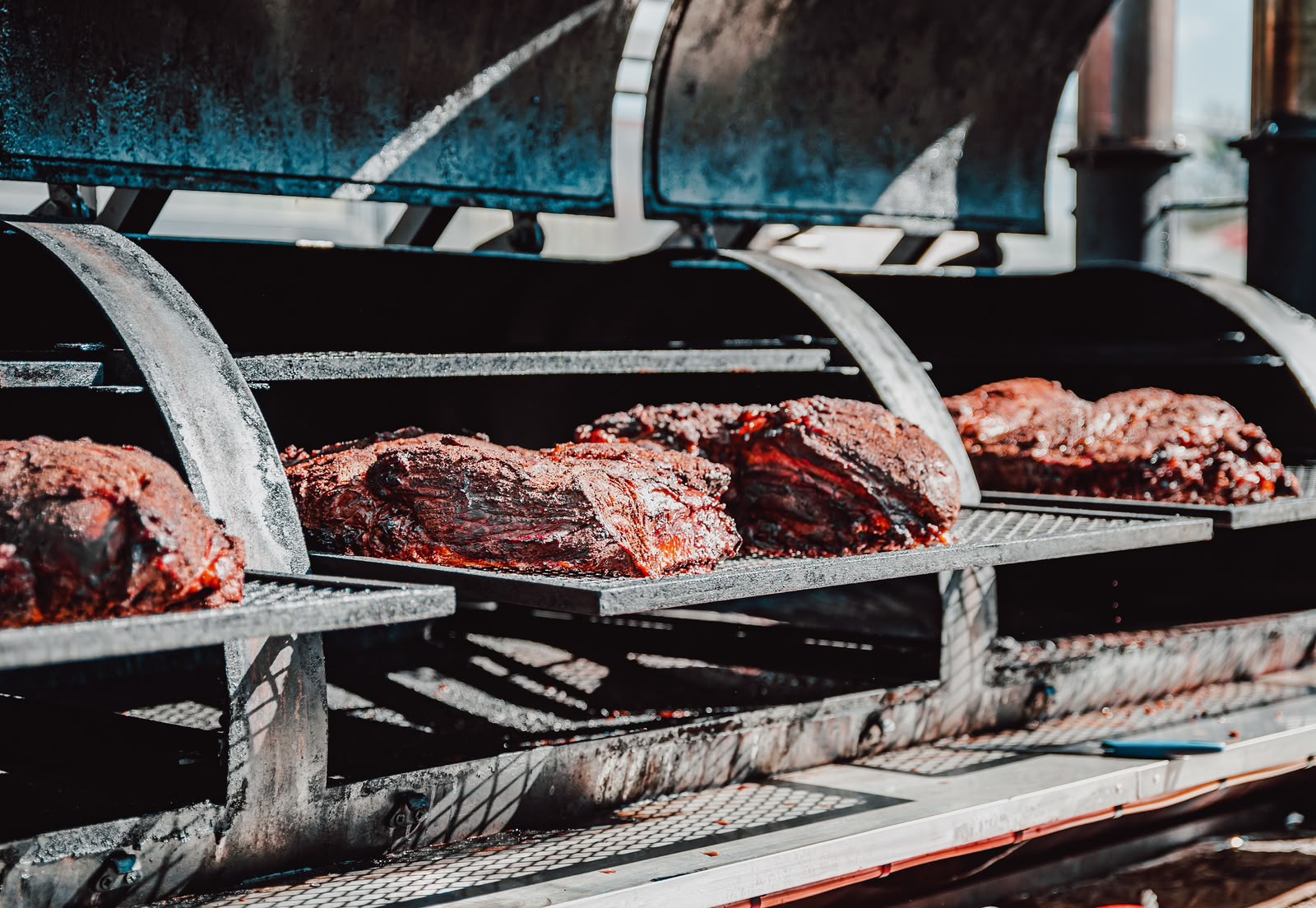 Fleisch im offenen Offset-Smoker beim langsamen Räuchern