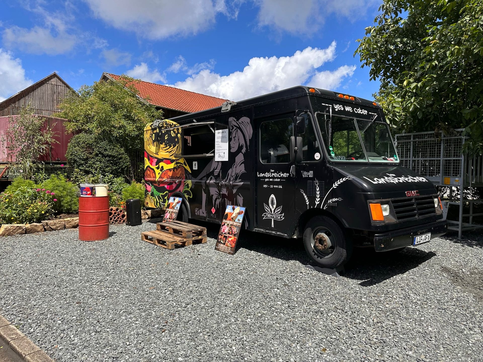 Der schwarze Landstreicher-Foodtruck auf einem Kiesplatz im Sommer