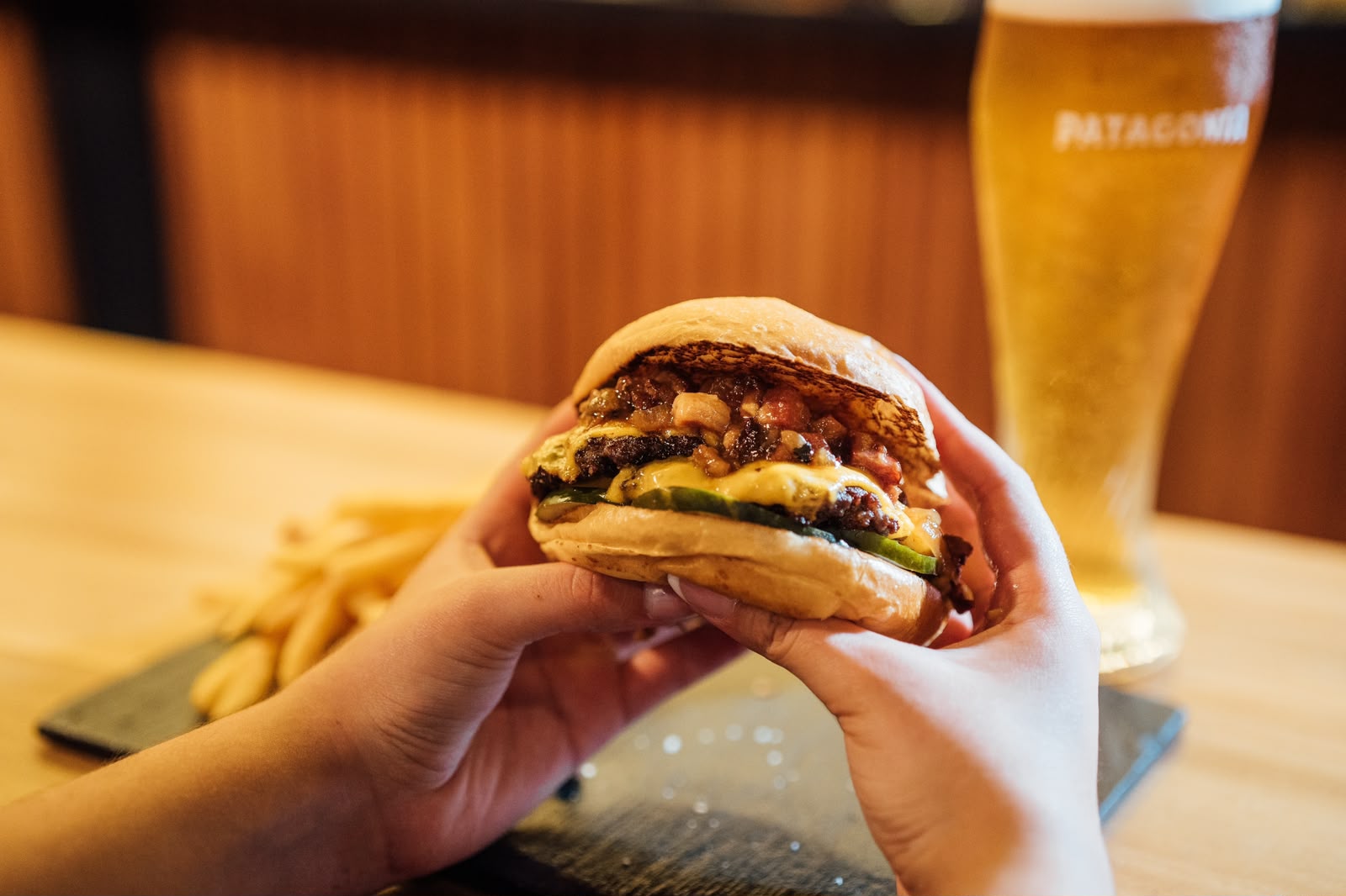 Veggie-Burger mit Weizenprotein-Patty, geschmolzenem Käse und Gemüse in der Hand